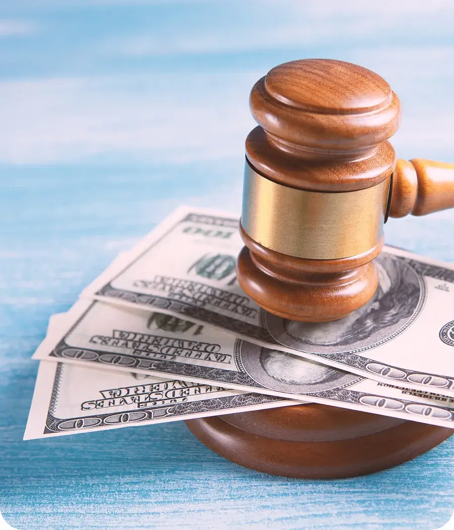 Court gavel and stack of money at the bottom