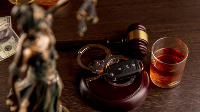 Gavel with an alcoholic drink and handcuffs