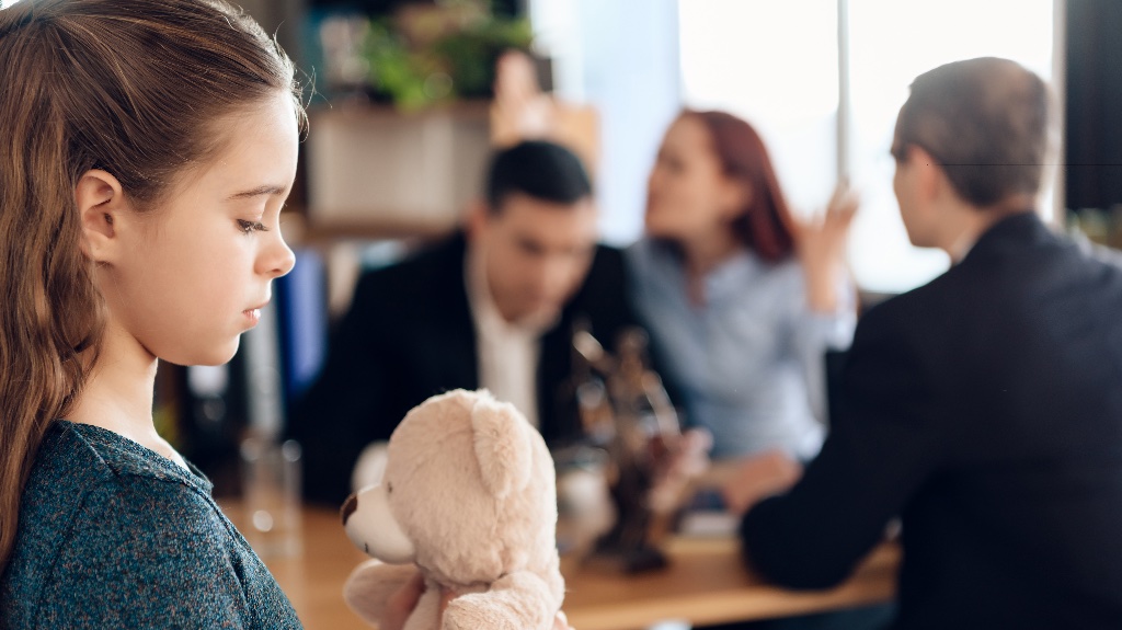 two parents arguing with a lawyer while little girl is present
