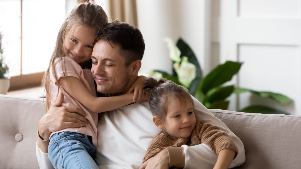 father with his kids sitting on the couch