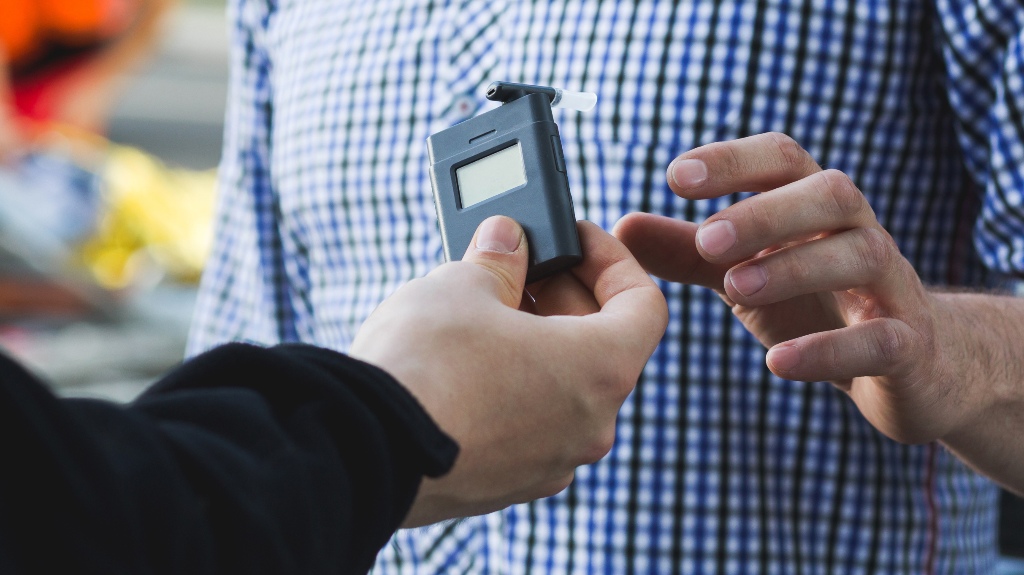Policeman giving a breathalyzer to a driver