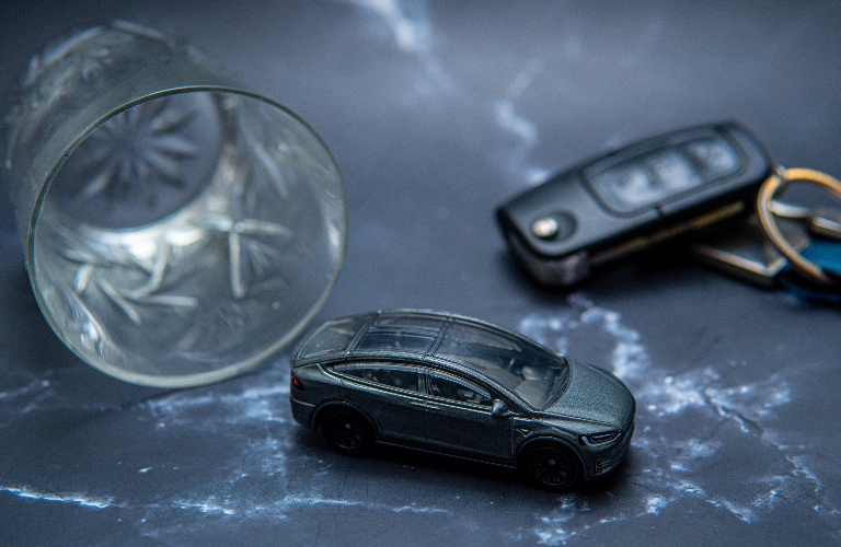 toy car next to glasses with alcohol